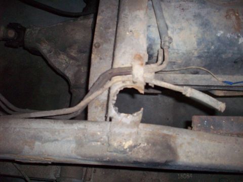 1978 Jeep CJ5 - Close-up view of a heavily rusted vehicle frame and associated lines, with visible damage.