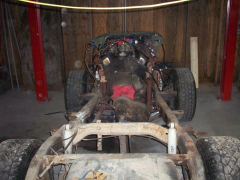 1978 Jeep CJ5 - The chassis and engine of a 1978 Jeep CJ5 are shown, with suspension components and tires in place.