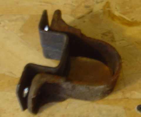 1969 Ford Fairlane - A close-up view of a single, aged metal bracket with a curved section and two pointed ends.