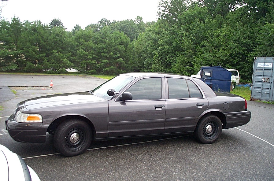 Side view of a dark gray 2001 Ford Crown Victoria sedan with black steel wheels