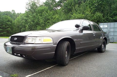 2001 Ford Crown Victoria - Dark gray 2001 Ford Crown Victoria police car with black wheels and a light bar visible.