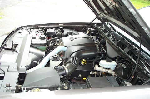 2001 Ford Crown Victoria - The engine bay of a vehicle is shown with the hood open, revealing the V8 engine and associated components.