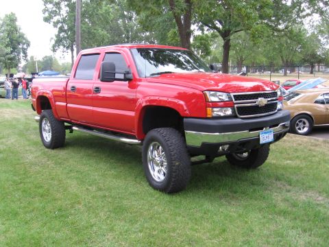 2001 Chevrolet Silverado 1500 - This lifted red 2001 Chevrolet Silverado 1500 pickup truck is shown in a 3/4 front view.