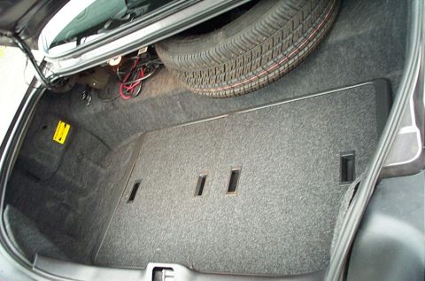 2001 Ford Crown Victoria - The trunk of a 2001 Ford Crown Victoria, the spare tire and carpeted interior.