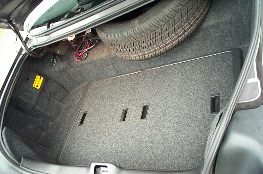 Trunk interior of a 2001 Ford Crown Victoria showing spare tire and carpeting