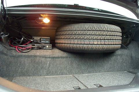 2001 Ford Crown Victoria - Spare tire and CB radio installed in the trunk of a vehicle.