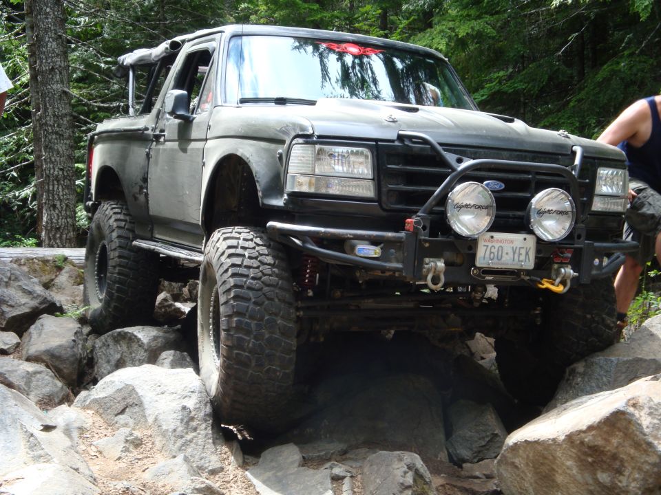 Ford Bronco on rocks, front bumper with lights and winch, license plate 760-YEK