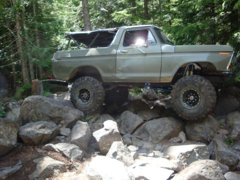 1978 Ford Bronco - This modified SUV is navigating a challenging rocky terrain, its off-road capabilities.