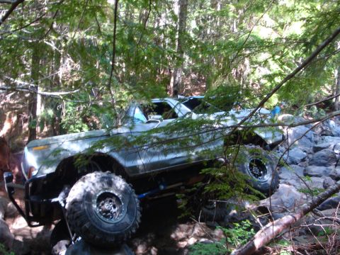 1978 Ford Bronco - Modified 1978 Ford Bronco tackling a challenging off-road course in the woods.
