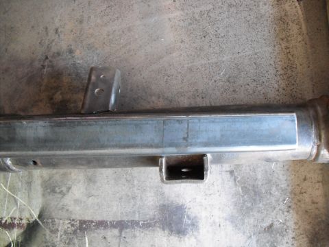 1991 Ford Bronco - A close-up view of a metal axle component with welded brackets, likely undergoing installation or repair.