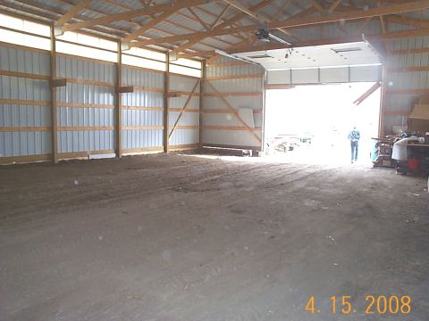 1984 Ford Mustang - Interior view of a large barn or garage structure with an open bay door.