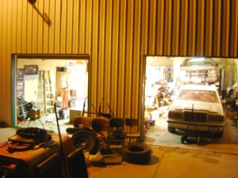 1984 Ford Mustang - Two vehicles, a sedan and a truck, are parked inside a garage.