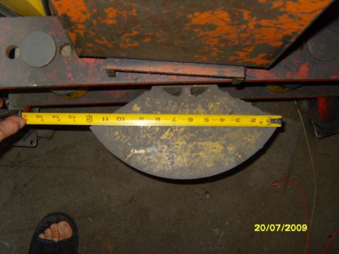 1989 Ford Bronco - A yellow tape measure is used to measure a circular metal part, likely from a vehicle component.