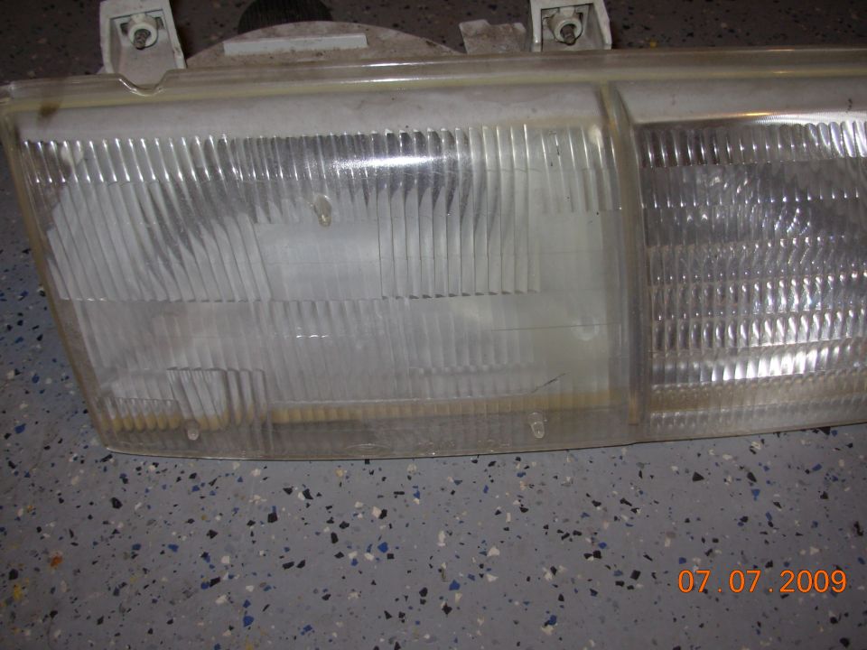 Headlight assembly with clear, ribbed lens and visible mounting points