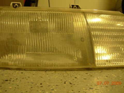 1995 Ford Taurus - Headlight assembly with visible text on the lower edge.