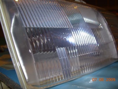 1995 Ford Taurus - A close-up view of a clear car headlight assembly, showing its textured lens.