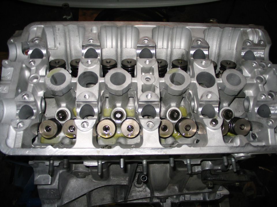 Aluminum 4-cylinder head with camshaft removed, valve springs and cam towers exposed during rebuild