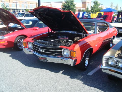 1991 Nissan Micra - A red 1972 Chevrolet Chevelle SS is displayed with its hood open at an outdoor car show.