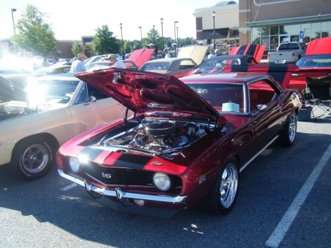 1991 Nissan Micra - A classic Chevrolet Camaro SS is displayed with its hood open at an outdoor car show.