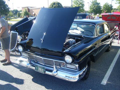 1991 Nissan Micra - A classic black Ford Fairlane 500 is displayed with its hood up at an outdoor event.
