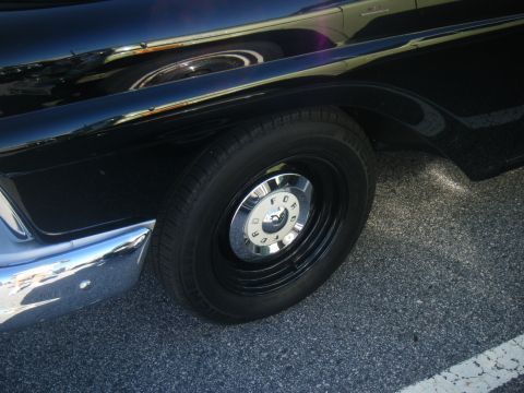 1991 Nissan Micra - Close-up of a black car's wheel and fender, showing a "FORD" branded hubcap.