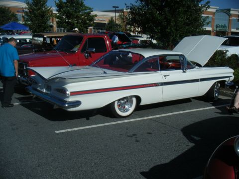 1991 Nissan Micra - A white 1959 Chevrolet Impala coupe is parked next to a red pickup truck.