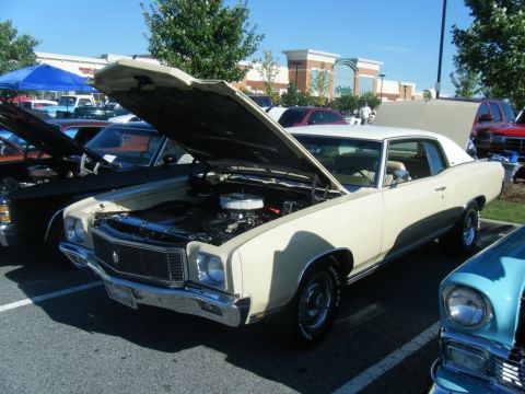 1991 Nissan Micra - Cream 1973 Chevrolet Monte Carlo coupe with hood open at a car show.