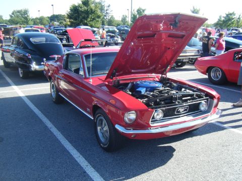 1991 Nissan Micra - A red classic car is parked with its hood open, revealing the engine, at an outdoor car show.