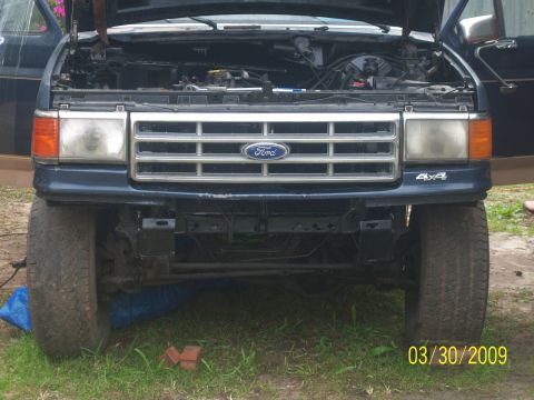 1987 Ford Bronco - Front view of a blue 1987 Ford Bronco with its hood open, revealing the engine compartment.