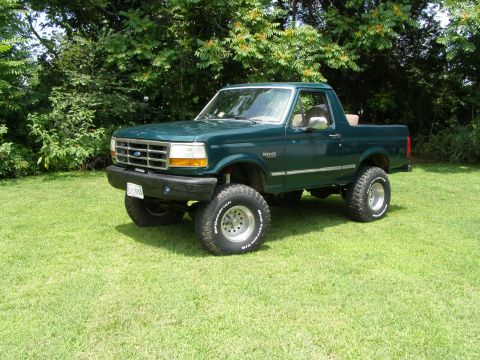 1993 Ford Bronco - This lifted 1993 Ford Bronco is presented in a three-quarter front view, its off-road tires and green exterior.