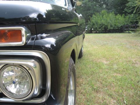 1966 Ford F-100 - Front view of a black 1966 Ford F-100 pickup truck with a shiny new paint job.