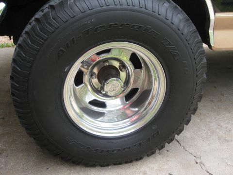 1994 Ford Bronco - Close-up of a chrome wheel and BFGoodrich All-Terrain T/A tires on a tan vehicle.