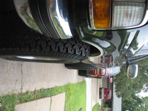 1994 Ford Bronco - A black 1994 Ford Bronco is parked in a driveway, showing off its large tires and chrome trim.