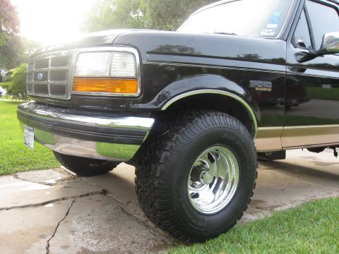 1994 Ford Bronco - This black 1994 Ford Bronco features chrome wheels and aggressive off-road tires, giving it a stance.