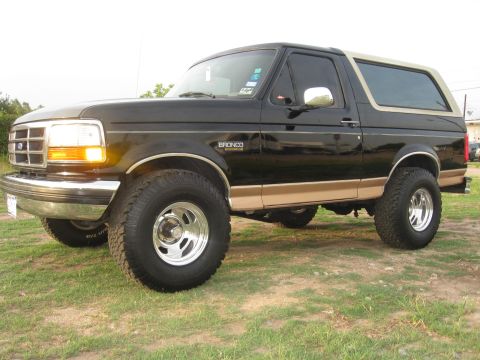 1994 Ford Bronco - This 1994 Ford Bronco is shown in a three-quarter front view, its distinctive black and tan paint scheme and lifted suspension.