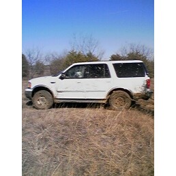 1989 Ford Bronco - A white Ford Expedition is seen from the side in a dry, grassy field under a clear blue sky.