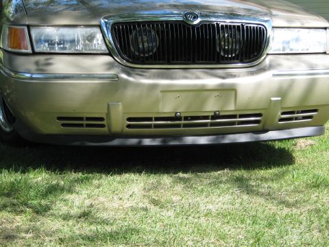 2000 Mercury Grand Marquis - Front view of a gold 2000 Mercury Grand Marquis, showing the grille and headlights.