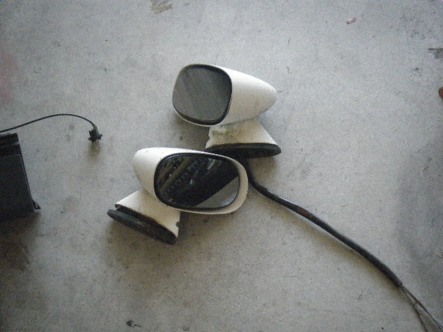 Pair of white side mirrors with black bases and wires
