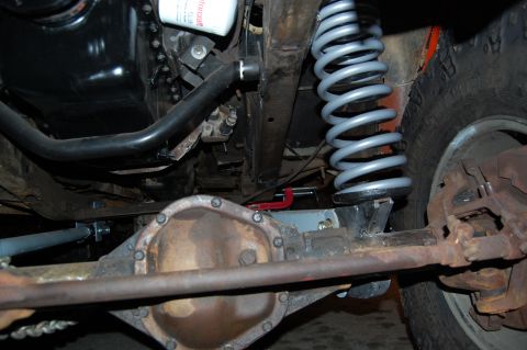 1994 Ford Bronco - Close-up view of a vehicle's undercarriage, focusing on the suspension and drivetrain components.
