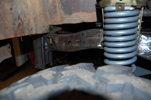1994 Ford Bronco - Detail of a vehicle's suspension system, focusing on the coil spring and frame components.