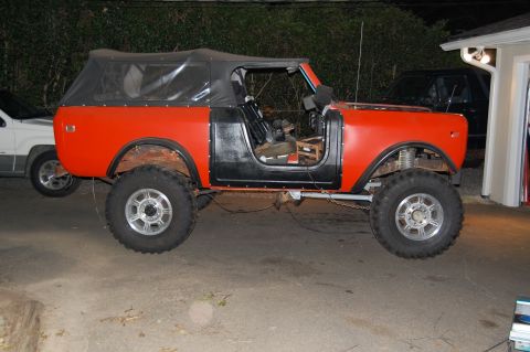 1994 Ford Bronco - This lifted International Scout II is parked next to another vehicle in a driveway.