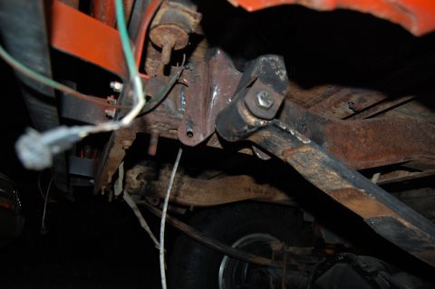 1994 Ford Bronco - This photo shows the rusty undercarriage of a vehicle, focusing on suspension components and exposed wiring.