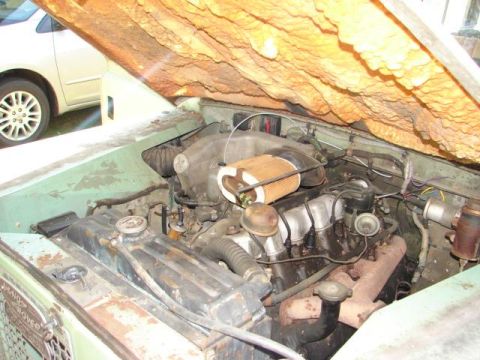 1967 Land Rover Land Rover - The engine bay of a 1967 Land Rover Land Rover shows its mechanical components and insulation.