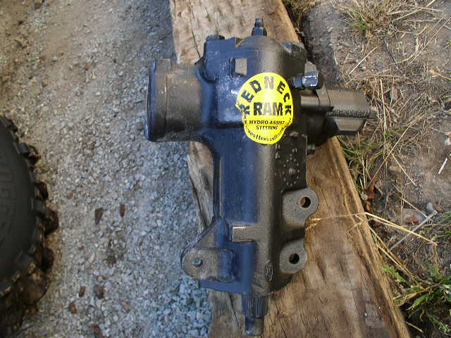 Blue rebuilt Ford steering box with a yellow Redneck Ram hydro-assist sticker on a plank