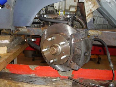 1969 MINI Cooper - Close-up view of a vehicle's brake caliper and rotor assembly, likely undergoing maintenance or repair.