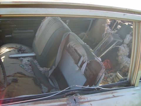 1971 Pontiac Lemans - The interior of a car shows heavily damaged seats and insulation, with no clear year identification.