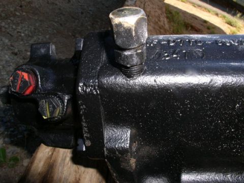 1979 Ford Bronco - A black power steering gearbox is shown, with visible stamped numbers and bolts on its surface.