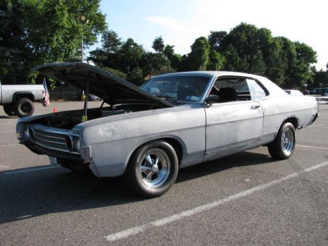 1969 Ford Torino - This 1969 Ford Torino is in primer and has its hood open, parked outdoors.