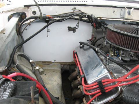 1979 Ford Bronco - Close-up view of a V8 engine in an engine bay, chrome valve covers and red spark plug wires.