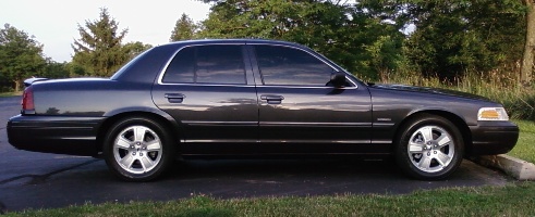 Charcoal four-door sedan in side profile parked on grass